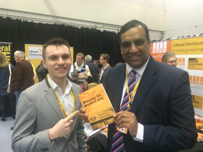 Shaffaq Mohammed and colleague pointing at a Lib Dem book