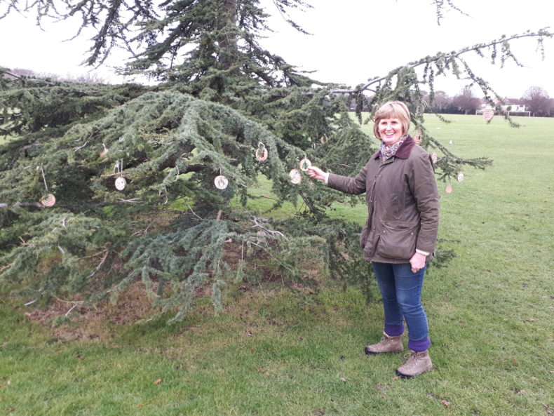 Mary Burstow pointing at a Christmas tree