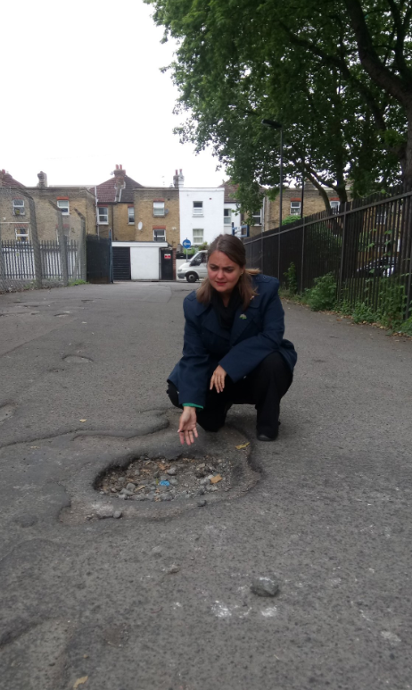 Lucy Salek pointing at a pothole in Lewisham East by-election