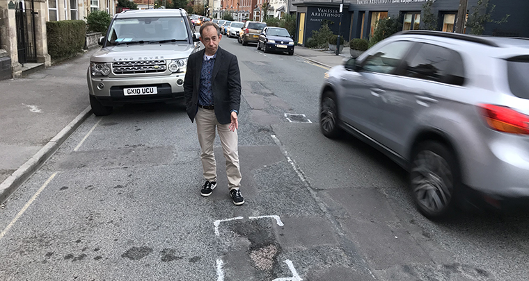 Gary Selwyn pointing at a pothole - Cotswold Liberal Democrats
