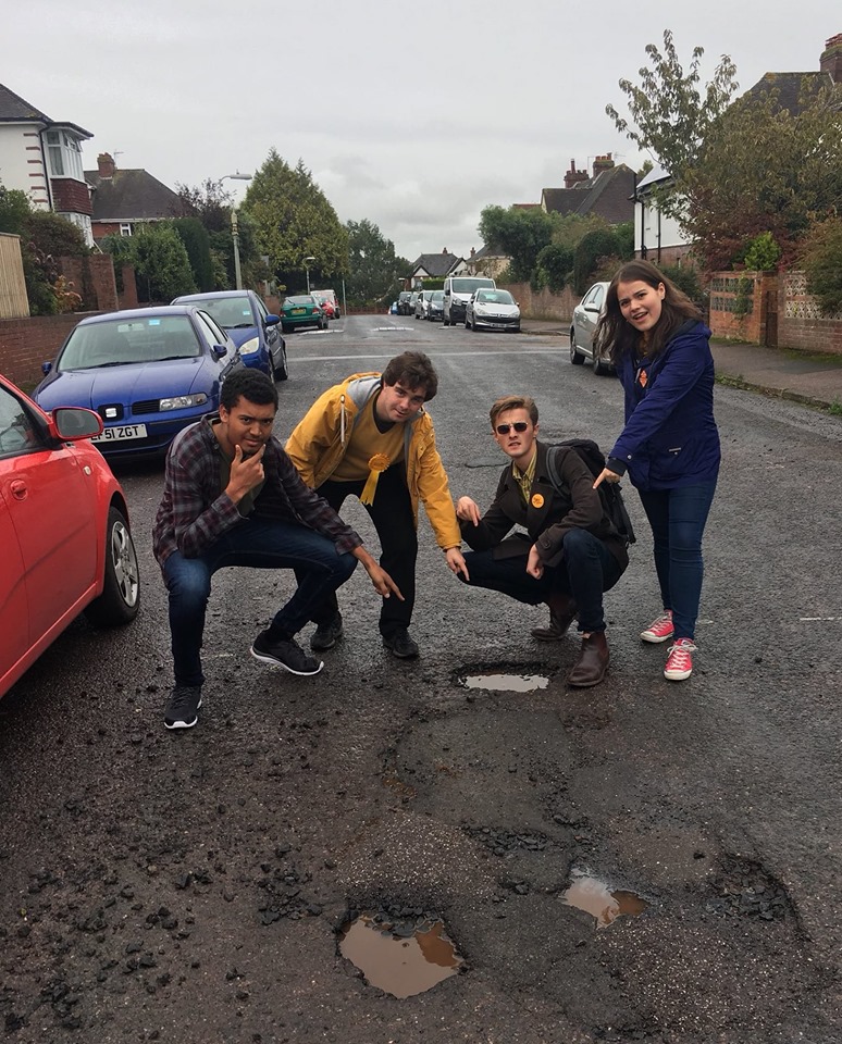 Exeter University Liberal Democrats pointing at potholes with style