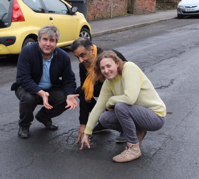 Bex Atkinson, Tim Huggan and Mahroof Mohammed pointing at a Sheffield pothole