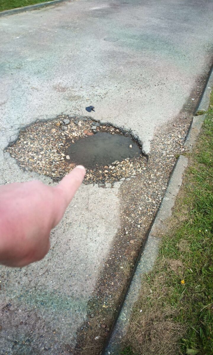 Mark Pack pointing at a pothole