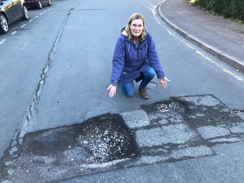 Karin Rowsell points at a pothole